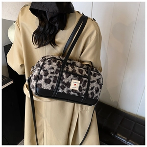 Detail of leopard print plush pillow bag with logo patch and black leather trim