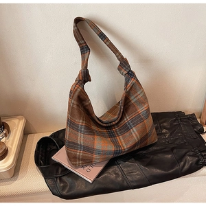 Detail of a brown plaid woolen tote bag texture with orange and charcoal patterns