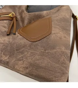 Close-up of brown vintage tote bag with golden zipper and long decorative tassels