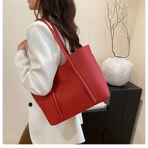 Detalle de bolso tote rojo en cuero con textura litchi y gran capacidad de almacenaje