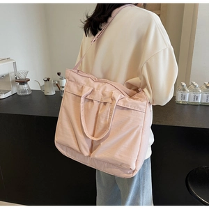 Detailed back view of a pink large capacity tote bag worn as a crossbody on a model