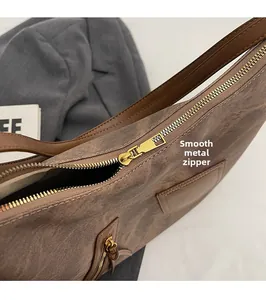 Close-up of smooth golden hardware zipper on vintage brown canvas shoulder bag detail