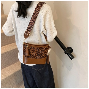Detail of leopard print patchwork crossbody bag with brown leather fringe and gold hardware