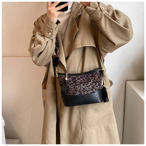 Detail of leopard print canvas and black leather crossbody bag with fringe tassel