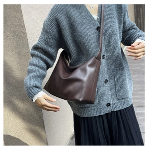 Side view of large dark brown leather hobo bag worn by model in casual outfit