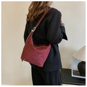 Detail showing the burgundy frosted leather texture and brown adjustable shoulder strap