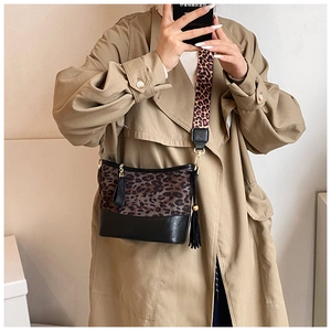 Close-up of leopard print patchwork crossbody bag with long black decorative tassels