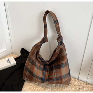 Detail of vintage plaid fabric hobo bag with a stylish knot shoulder strap design