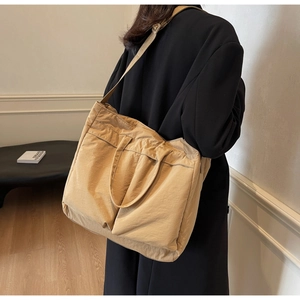 Khaki large capacity nylon tote bag with dual front pockets shown on a model for daily use
