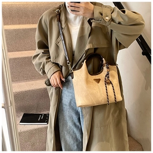 Détail du sac fourre-tout kaki avec plaque en métal et foulard décoratif en selfie miroir