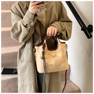 Détail du sac cabas beige avec pièce en métal doré et breloque en corde tressée