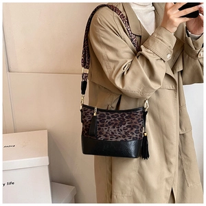 Detail of trendy leopard print crossbody bag with chain and black leather base