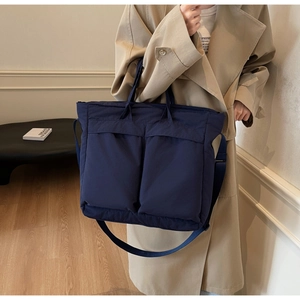 Detail of navy blue large tote bag showing functional cargo pockets and dual straps