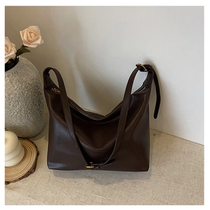 Detail of a large dark brown hobo shoulder bag with retro bronze hardware accents