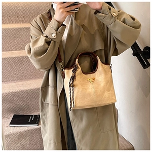 Détail du sac cabas beige avec bordure en cuir marron et lanière tissée décorative