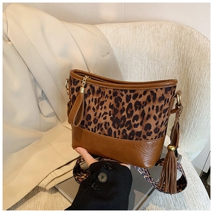 Detail of leopard print bucket bag with brown leather trim and wide crossbody strap