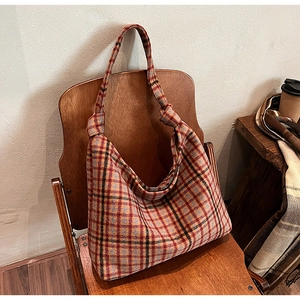 Detail of tartan checkered wool tote bag with a unique knot decorative shoulder strap