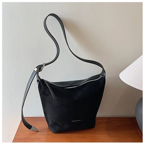 Detailed close-up of a black frosted suede tote bag with FASHION & BAGS printed on the front