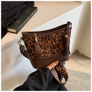 Close-up of leopard print bucket bag with leather tassels and wide patterned strap