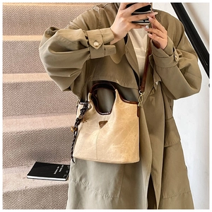 Détail d'un sac cabas beige avec des anses en cuir marron et un foulard en soie décoratif