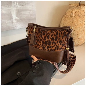 Detail view of leopard print shoulder bag with brown leather trim and tassel accent