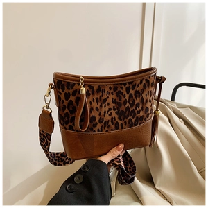 Detail of leopard print crossbody bag with wide strap and brown leather stitching