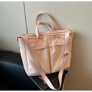 Close-up of pink puffer tote bag featuring double handles and adjustable nylon shoulder strap