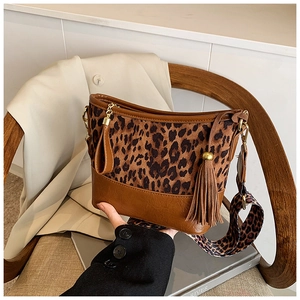 Detail of hobo bag with leopard print fabric, brown leather trim and wide shoulder strap