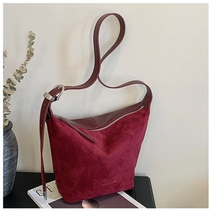 Close-up of burgundy frosted suede hobo bag with fashion logo and metallic details