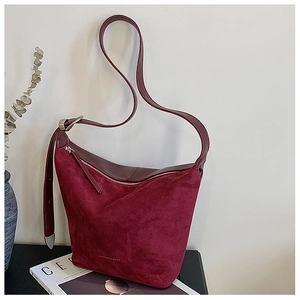 Detail view of burgundy frosted leather bucket bag with silver zipper and metallic strap ends
