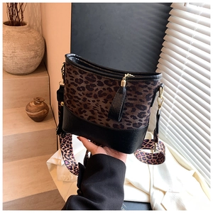 Detail of leopard print bucket bag with black leather trim and gold-toned hardware