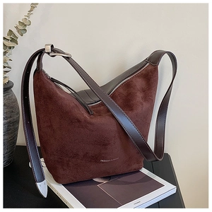 Detail of dark brown matte suede hobo bag with white Fashion text and silver ring