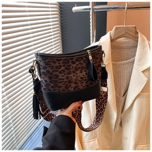 Close-up of leopard print bucket bag with black leather base and gold zipper detail