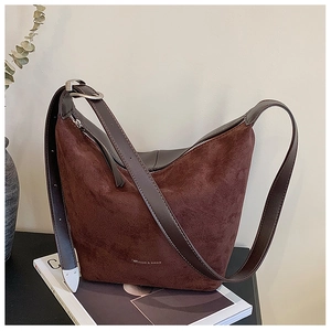 Detail of adjustable leather strap with silver buckle on a dark brown suede tote bag
