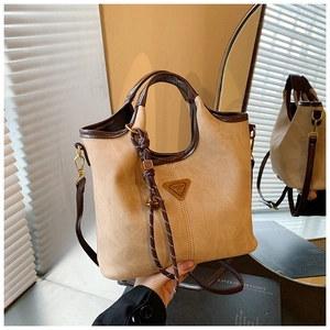 Détail d'un sac cabas beige minimaliste avec garniture en cuir et des poignées