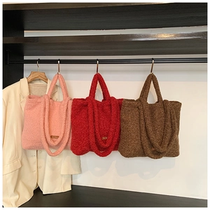 Detailed close-up of soft plush tote bags in pink, red, and brown fleece textures