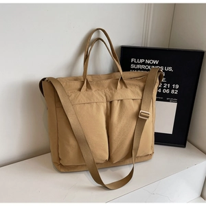 Detail of earthy tote bag with two front pockets and adjustable wide fabric strap