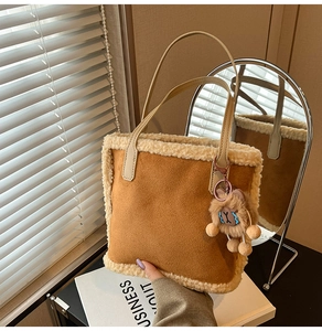 Gros plan du sac en daim marron avec bordure en molleton et pendentif ours en peluche