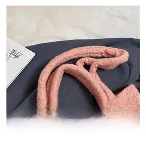 Close-up of the thick plush shoulder strap on a soft pink faux fur tote bag