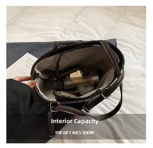 Detail view of large capacity dark brown tote bag showing internal pockets and storage