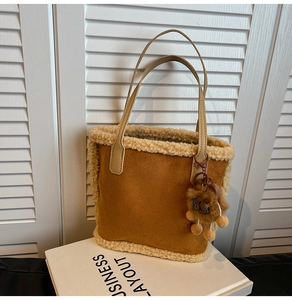 Détail du sac cabas en suédine caramel avec bordure en peau lainée et breloque lion