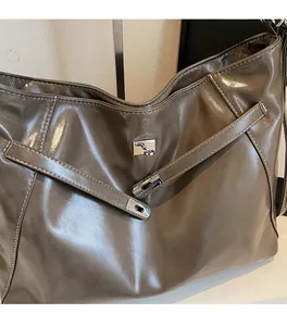 Détail du grand sac cabas marron avec surpiqûres blanches et fermoir rotatif argenté