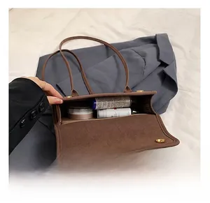 Detail view showing large capacity interior of brown suede tote bag with cosmetic items