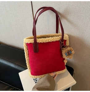 Détail du sac à main en daim rouge avec garniture en peau de mouton et breloque