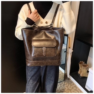Close-up of dark brown vintage tote bag with contrast stitching and flap pocket detail