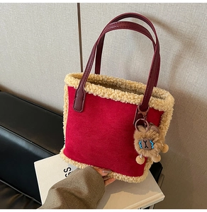 Détail du sac cabas en daim rouge avec bordure en peau lainée et charm ourson