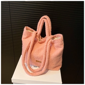 Close-up of pink fuzzy tote bag with twin handles and small our fave label detail