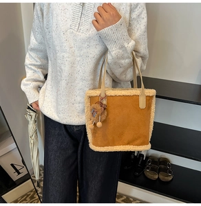 Détail d'un sac cabas en daim avec doublure en peau de mouton et charme en peluche