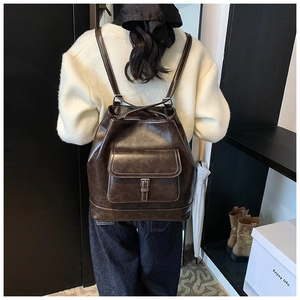 Detail view of dark brown vintage faux leather backpack with contrast stitching