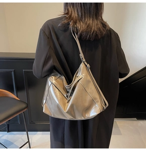 Macro shot of metallic bronze tote bag made of high-shine patent leather with slim shoulder straps